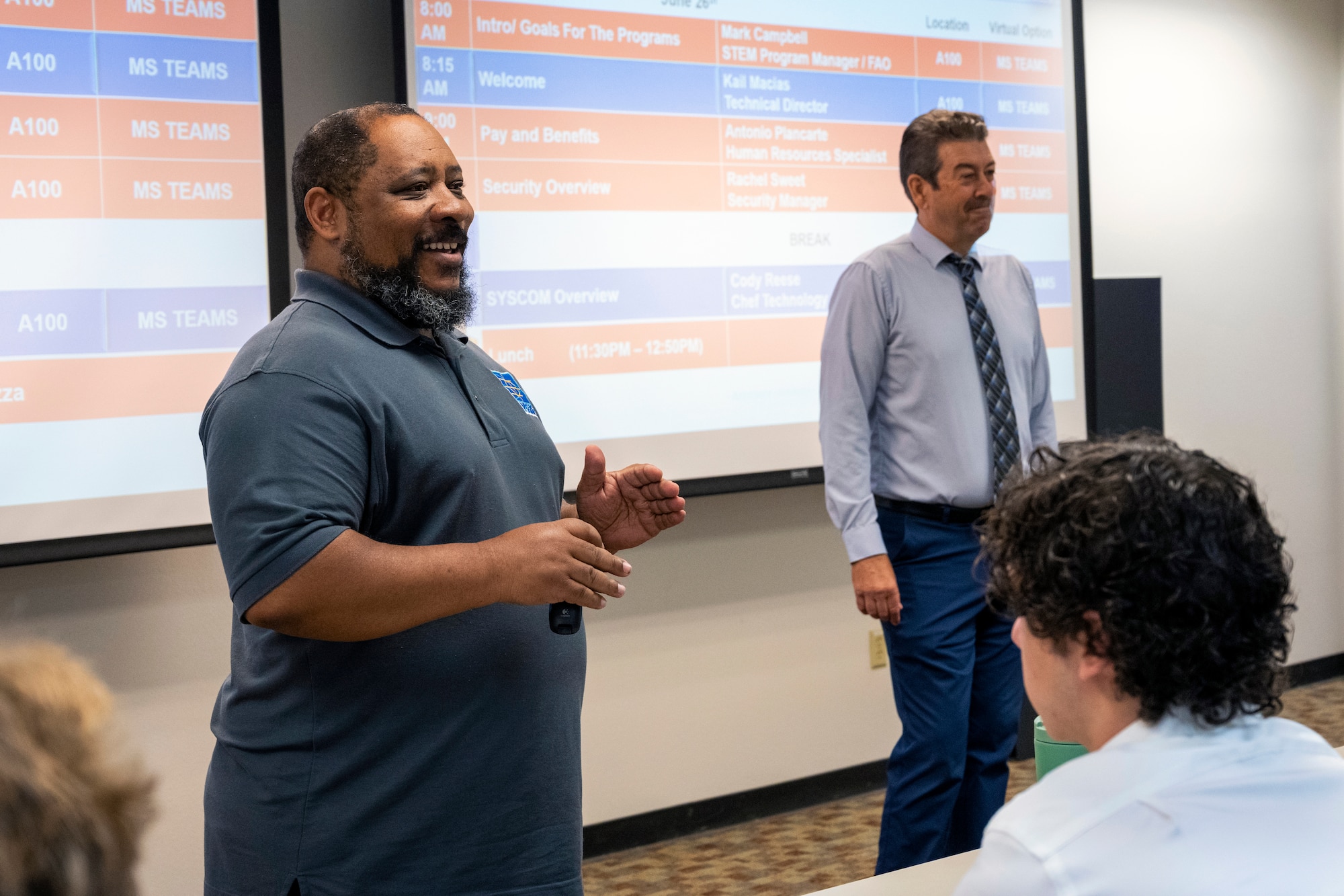 Man speaks in conference room to interns