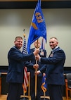 Col. Jeremy Patrick (left), 433rd Operations Group commander, hands the 433rd Aeromedical Evacuation Squadron guidon to Col. David Bailey (right), 433rd AES Commander, during an assumption of command ceremony at Joint Base San Antonio-Lackland, Texas, July 12, 2025.