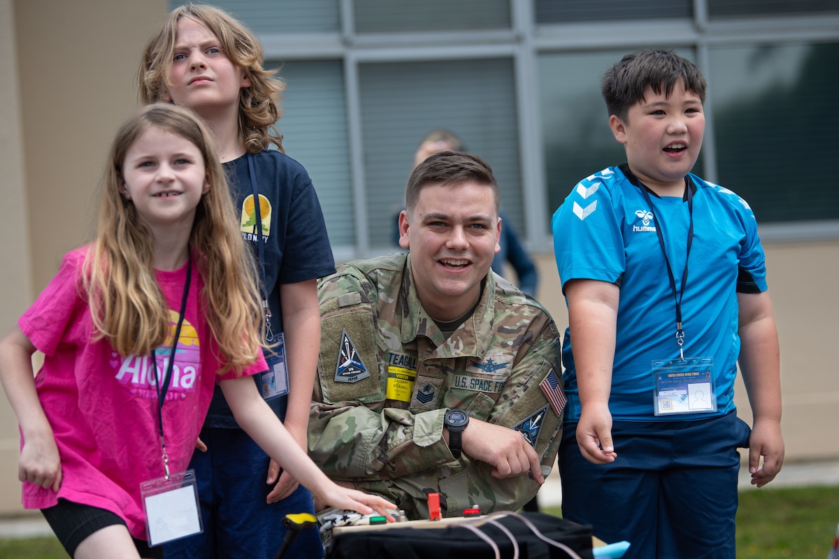 U.S. Space Force Tech. Sgt. Zachary Steagall, U.S. Space Forces-Japan missile warning NCO in charge, and Joan K. Mendel Elementary School students watch model rocket launches during a Space Systems Command STEM outreach event at Yokota Air Base, Japan, May 16, 2025. SSC outreach programs foster early interest in science, technology, engineering, and math, helping prepare future generations to support national defense and space operations. (U.S. Air Force photo by Airman 1st Class David S. Calcote)