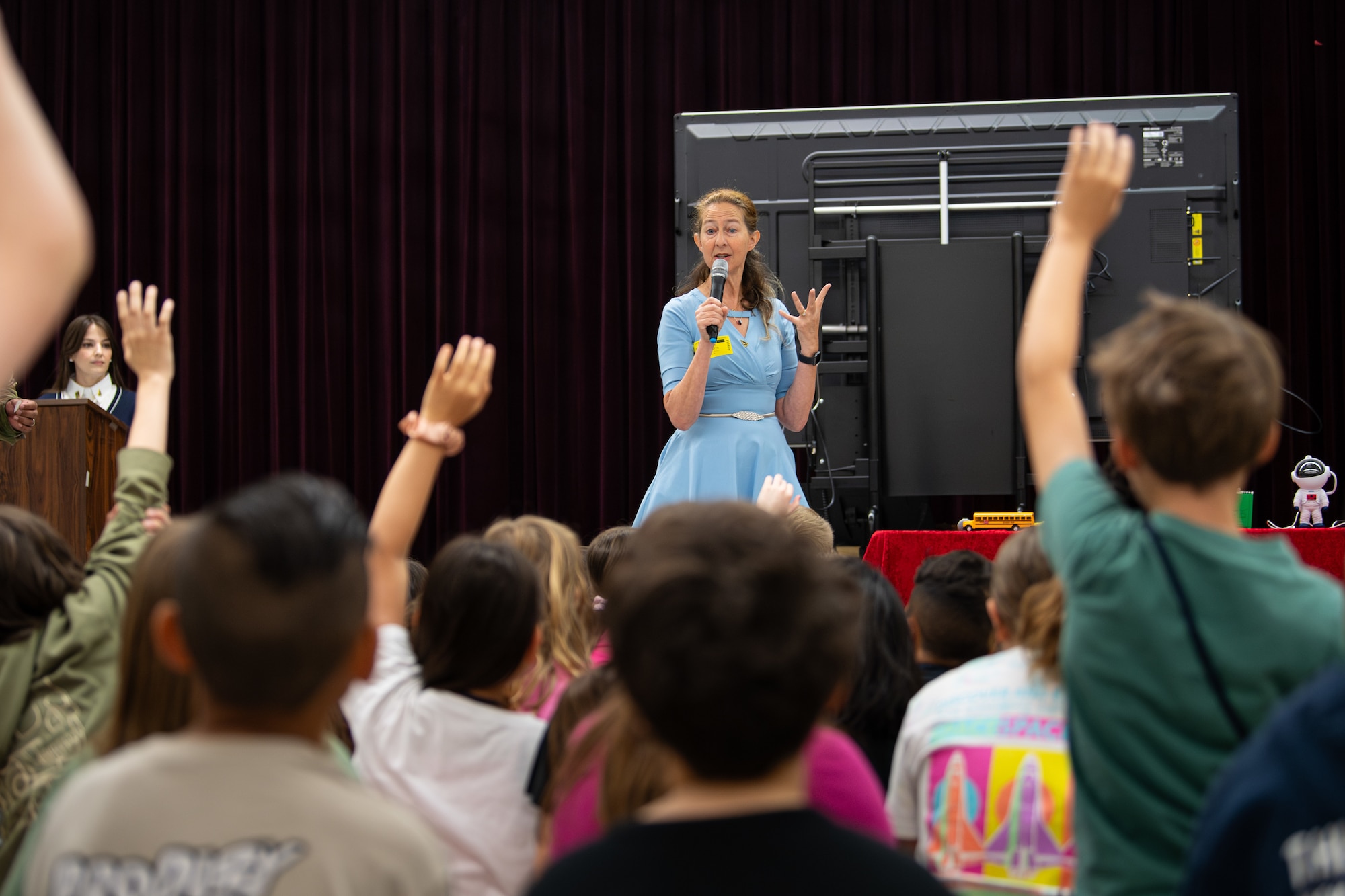Joan K. Mendel Elementary School students participate in a demonstration given by Nicole Tibbets, Space Systems Command STEM executive lead, during a SSC STEM outreach event at Yokota Air Base, Japan, May 15, 2025. SSC outreach programs foster early interest in science, technology, engineering, and math, helping prepare future generations to support national defense and space operations. (U.S. Air Force photo by Airman 1st Class David S. Calcote)