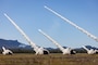 High Mobility Artillery Rocket Systems from the Australian Army, the United States Army and the Singapore Army fire a salvo of rockets during a combined joint live fire exercise in Queensland, Australia during Exercise Talisman Sabre 25.