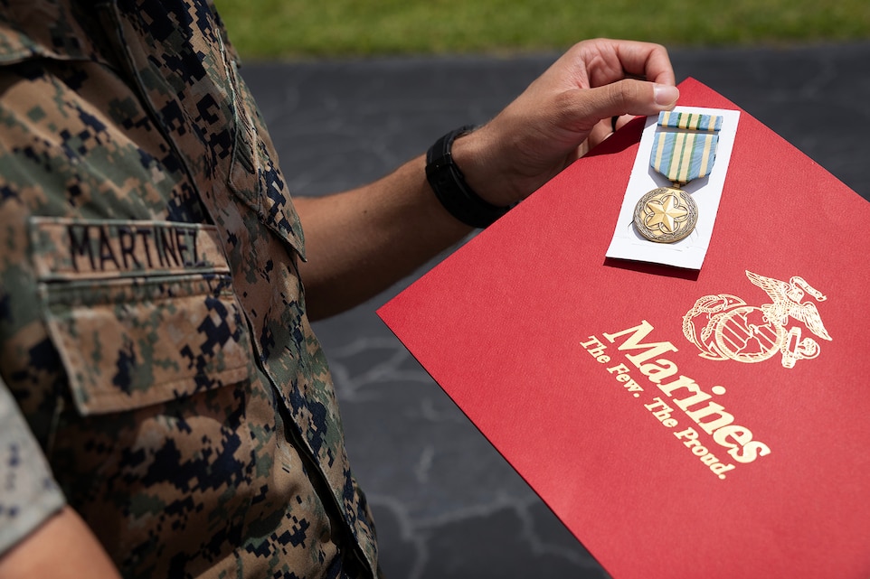 U.S. Marine Corps Cpl. Nicholas Martinez holds a Military Outstanding Volunteer Service Medal