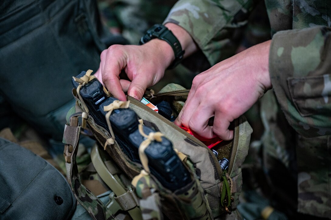 A U.S. Army paratrooper assigned to the 3rd Battalion, 509th Parachute Infantry Regiment, 2nd Infantry Brigade Combat Team (Airborne), 11th Airborne Division checks his gear at the Joint Mobility Complex during a personnel deployment function line in support of Talisman Sabre at Joint Base Elmendorf-Richardson, Alaska, July 13, 2025.