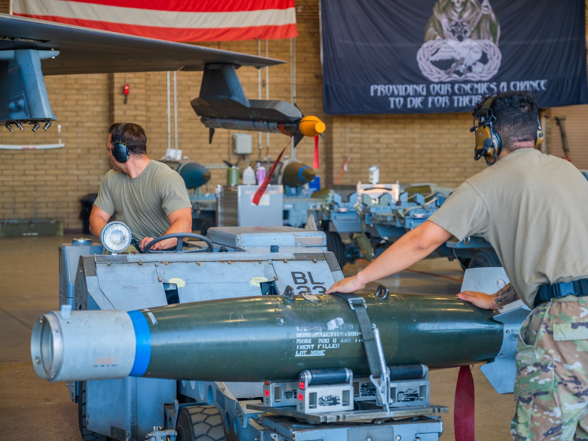 U.S. Air Force Senior Airman Mark Anthony Colon (rear), 62rd Aircraft Maintenance Unit weapons load team member, and Staff Sgt Aaron Aguilar (front), 56th Aircraft Maintenance Squadron weapons load team member, utalize a MJU-1 Lift Truck to load training ordnance on the wing of an F-35A Lighnting II during the 56th Fighter Wing’s third quarterly load competition, July 11, 2025, at Luke Air Force Base, Arizona.
