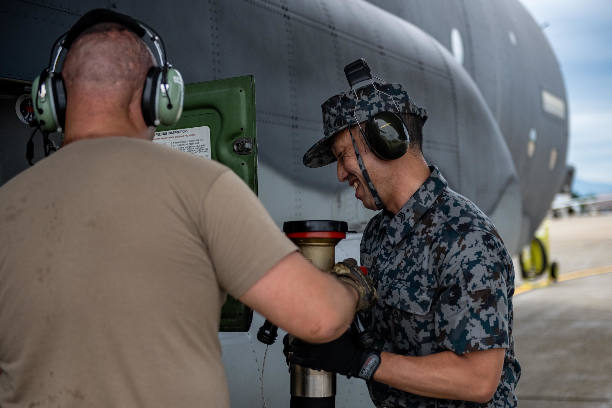 U.S. Air Force Master Sgt. Jordan Benshoof, left, 129th Aircraft Maintenance Squadron crew chief lead, and Japan Air Self-Defense Force Sgt. 1st Class Kasauki Okubo, 3rd Air Wing petroleum, oil, and lubricant technician, unhook a fuel line from a U.S. Air Force C-130J Super Hercules during exercise Resolute Force Pacific (REFORPAC) 2025.
