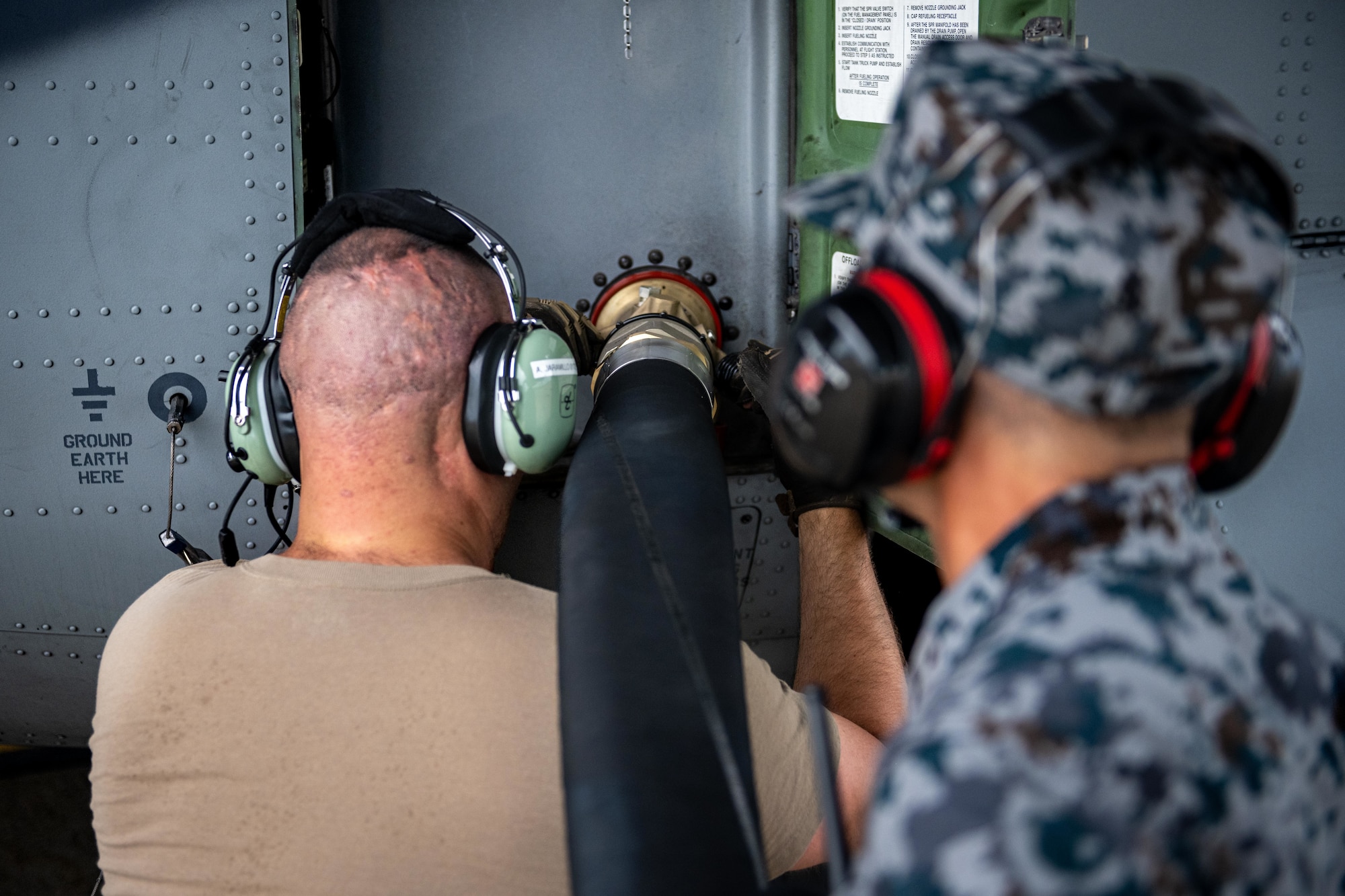 U.S. Air Force Master Sgt. Jordan Benshoof, 129th Aircraft Maintenance Squadron crew chief lead, and Japan Air Self-Defense Force Sgt. 1st Class Kasauki Okubo, 3rd Air Wing petroleum, oil, and lubricant technician, latch a fuel line into a U.S. Air Force C-130J Super Hercules during exercise Resolute Force Pacific (REFORPAC) 2025.