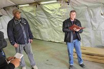 Alan Manzo, a property book specialist at Logistics Readiness Center Poland (right), briefs contractors and representatives from U.S. Army Europe and Africa as well as the mayor’s cell at Powidz, Poland, in March of 2025 on the proper procedure to descope the field shelters currently being used there and replace them with hardshell containerized housing and office units. (U.S. Army courtesy photo)