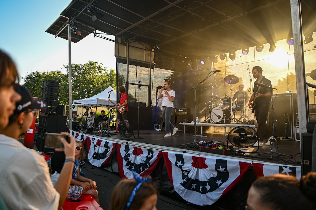 A band plays music on stage in front of a crowd.