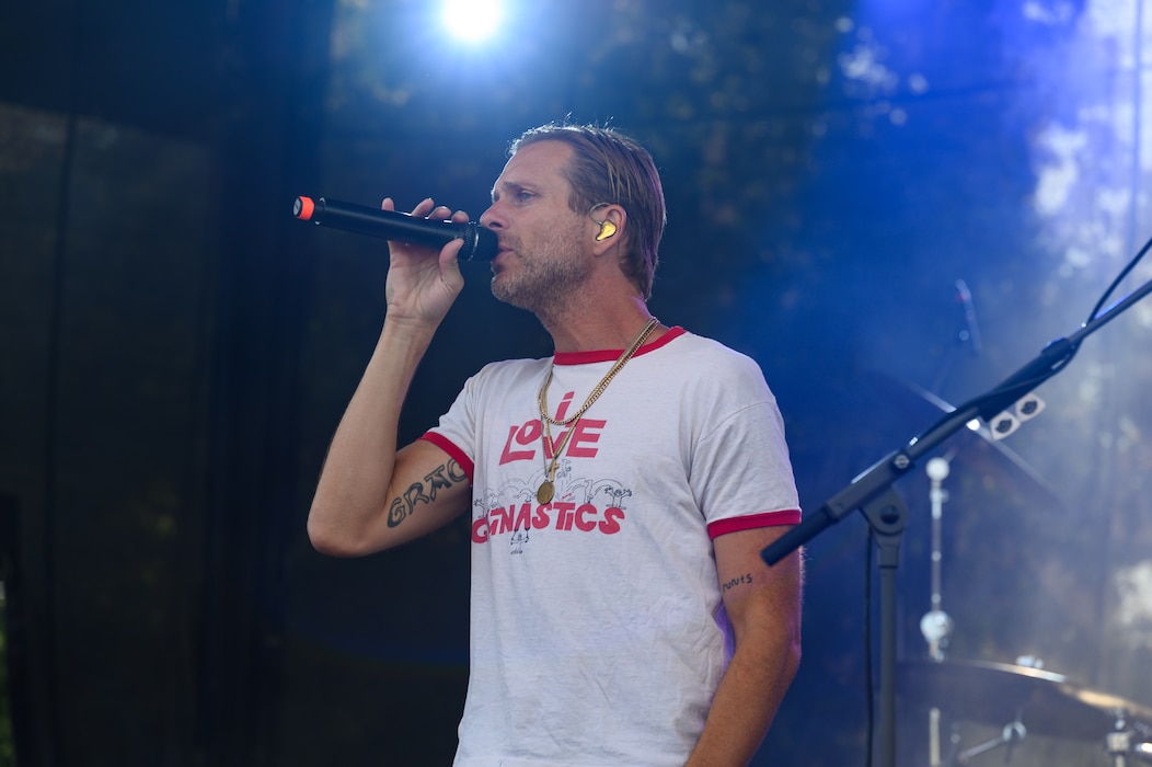 A man sings into a microphone on a stage.
