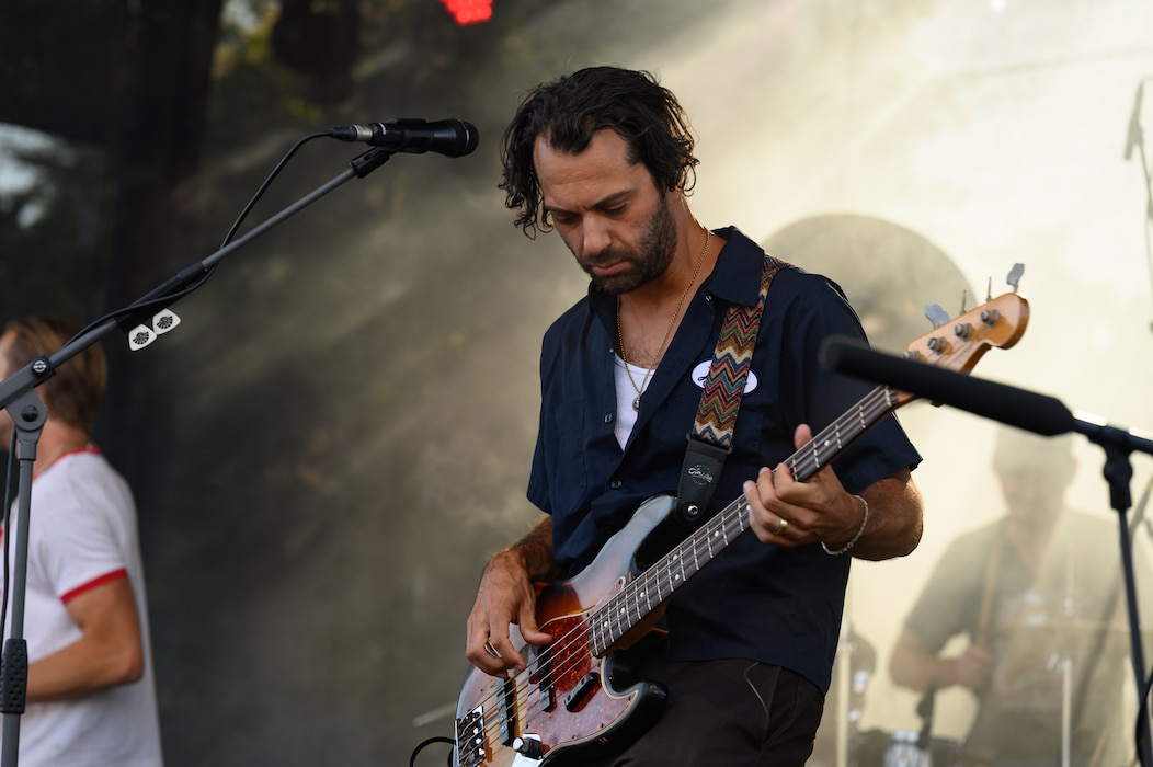 A man plays guitar on stage.