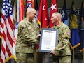 Senior leader presents the Charter certificate to Chief Warrant Officer 5 at the welcome ceremony.
