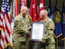 Senior leader presents the Charter certificate to Chief Warrant Officer 5 at the welcome ceremony.