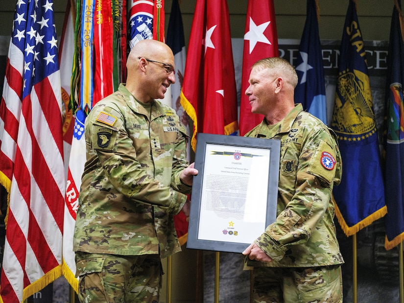 Senior leader presents the Charter certificate to Chief Warrant Officer 5 at the welcome ceremony.