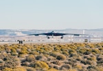 B-21 Raider hovers above desert ground while conducting flight testing.