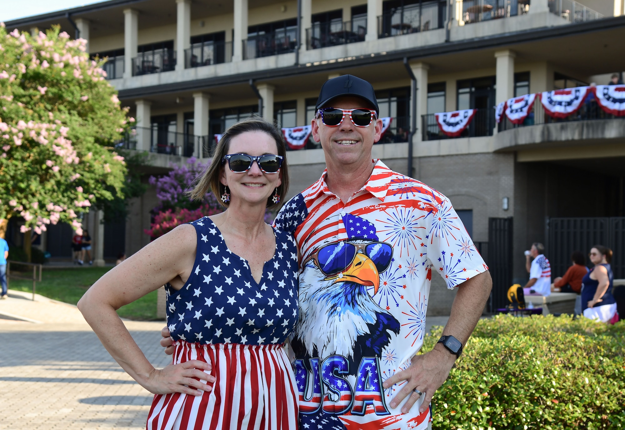 : a man and woman wearing red, white and blue shirts pose for a photo
