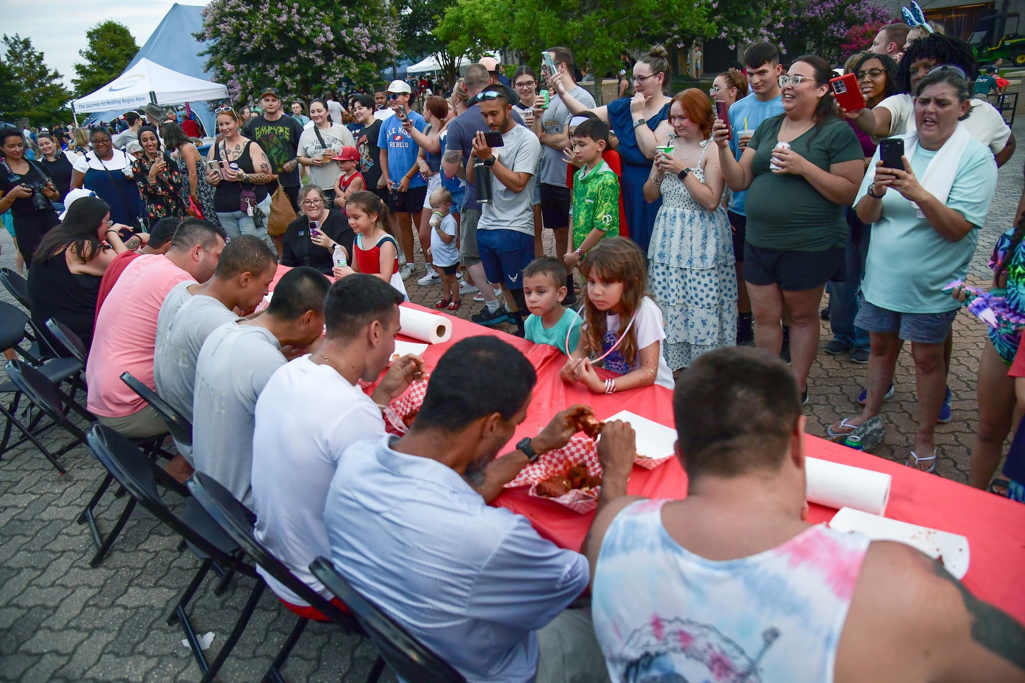 A group of men sit at a table eating hot wings