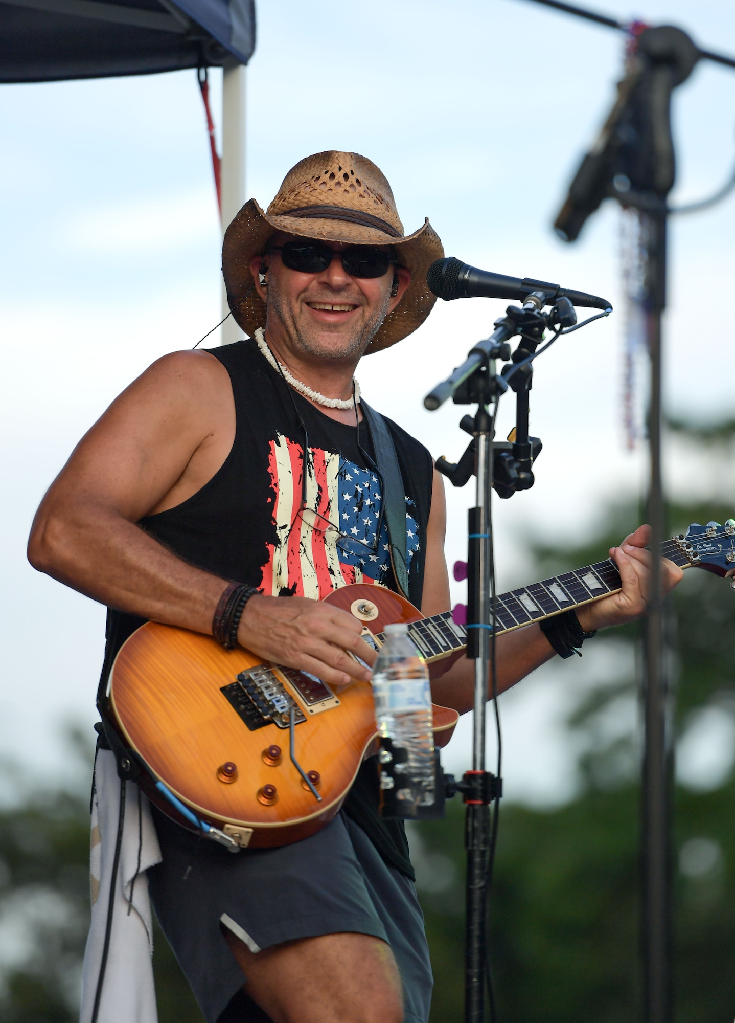A man wearing a cowboy hat plays a guitar