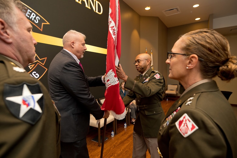 ERDC Chief of Staff Paul McDonald initiates the Change of Command Ceremony by passing the USACE flag to outgoing Commander Col. Christian Patterson.
