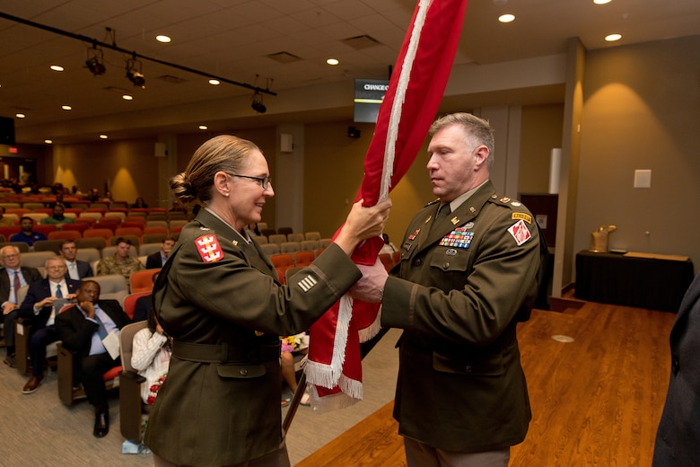 USACE Deputy Chief of Engineers and Deputy Commanding General Maj. Gen. Kimberly Colloton passes the USACE flag to new ERDC Commander Lt. Col. Joshua Haynes during the Change of Command Ceremony.