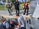 Crew members from U.S. Coast Guard Station Miami Beach and Maritime Safety and Security Team provide first aid to a man who suffered a severe leg injury after being struck by a boat propeller, near Elliot Key, July 15, 2025. The man was taken to the Jackson South Medical Center for a higher level of care. (U.S. Coast Guard Photo)
