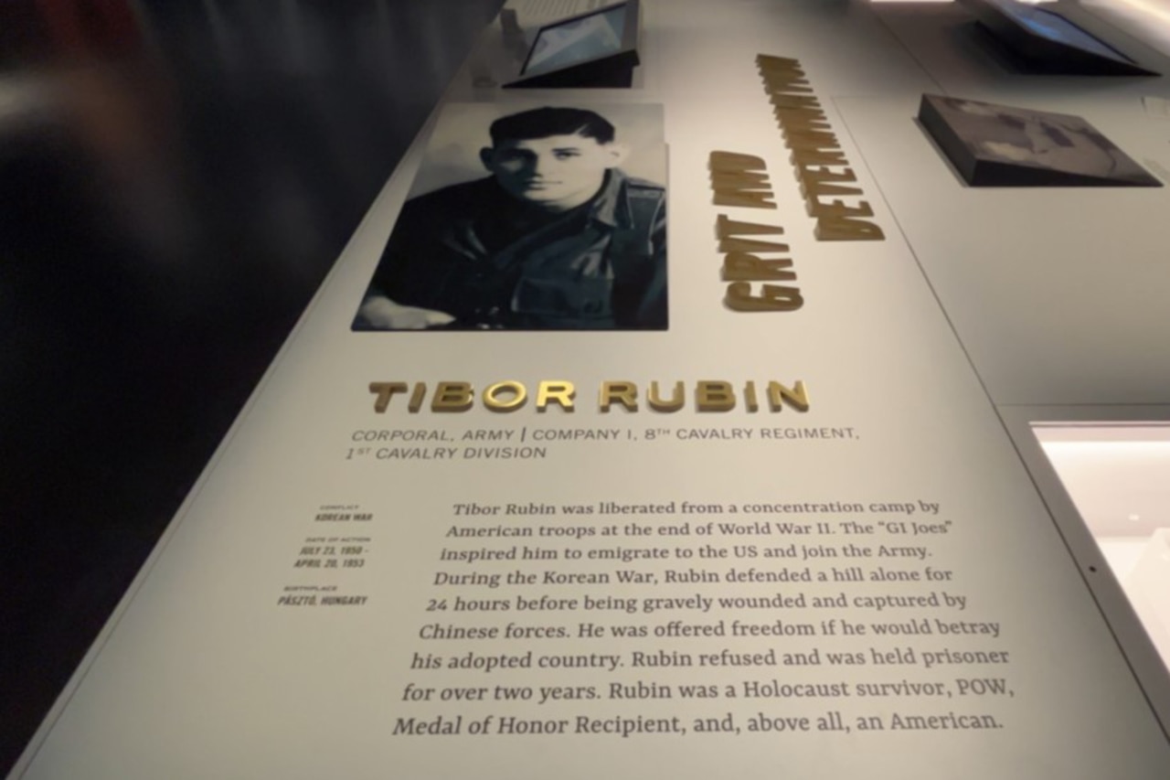 A photo and writing detailing the actions of a Medal of Honor recipient are posted in a display.