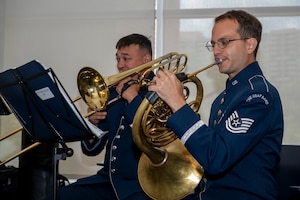 U.S. Air Force Master Sgt. Kaz Kruszewski, a trombone player, left, and Tech. Sgt. Joshua Blumenthal, a horn player, both with The U.S. Air Force Band’s Ceremonial Brass, perform during an enlistment ceremony at the Air & Space Forces Association headquarters in Arlington, Va., July 11, 2025. The performance of the Ceremonial Brass demonstrated the excellence displayed by all Airmen stationed worldwide, whose selfless service and sacrifices ensure the freedoms enjoyed by citizens of the United States of America. (U.S. Air Force photo by Hayden Hallman)