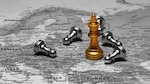 A black-and-white map of Europe and parts of Russia is overlaid with chess pieces. A prominent gold king stands in the area near Moscow, surrounded by toppled silver pawns, suggesting a geopolitical metaphor for dominance or conflict in the region.