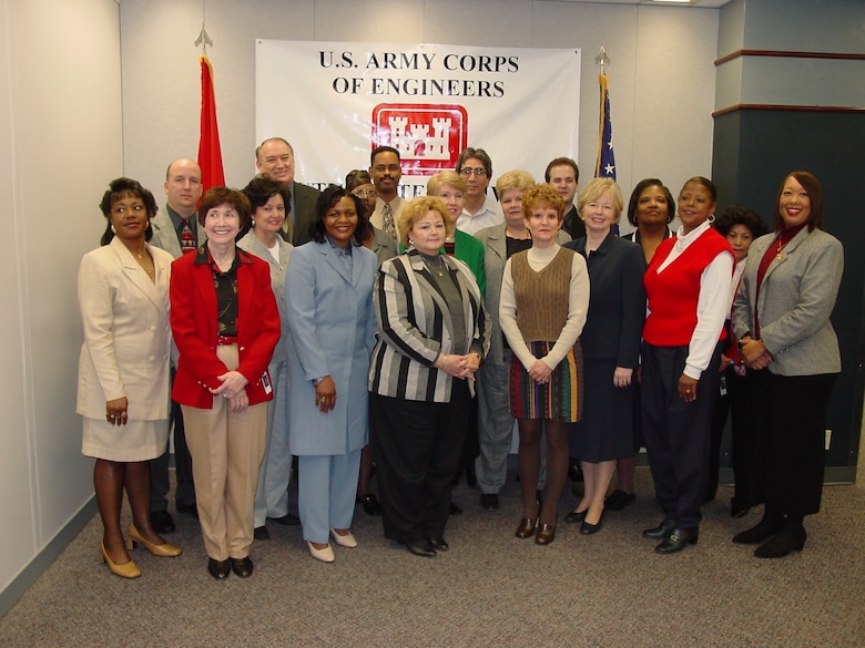 Keynote speaker Annette Young, wearing light blue, front row, third from left, poses for a group photo during the Civilian Personnel Advisory Center office holiday luncheon.