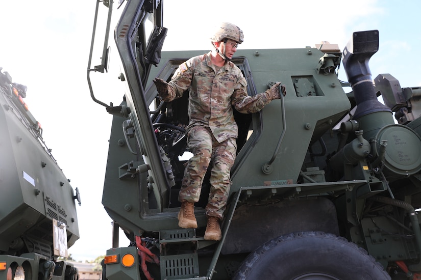 A soldier exits the driver side of a vehicle.