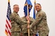 Men in uniform hold a flag.
