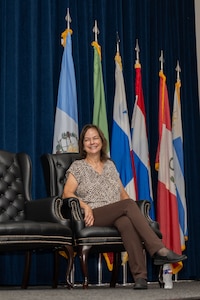 Anita Conder smiles while sitting on stage during her retirement ceremony.