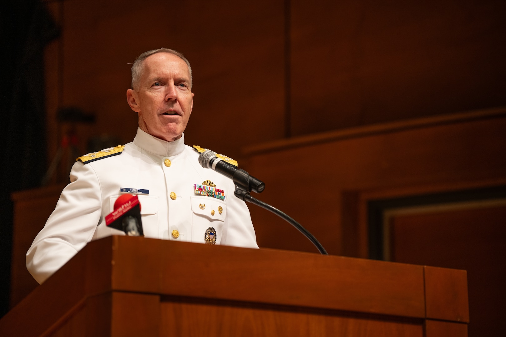 Acting Commandant of the Coast Guard Adm. Kevin Lunday gives a speech during a change of command ceremony inside Leamy Hall at the U.S. Coast Guard Academy, New London, Connecticut, July 16, 2025. Rear Adm. Gregory Rothrock relieved USCGA Superintendent Rear Adm. Michael Johnston to become the 44th superintendent of USCGA. (U.S. Coast Guard photo by Petty Officer Third Class Leo Avila.)
