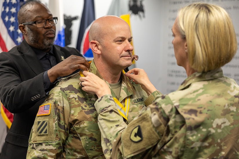 Col. Michelle M. Williams, U.S. Army Financial Management Command commander, right, and Gennaro Penn, U.S. Army Finance Corps Association president, left, present a Maj. Gen. Nathan Towson Regimental Medallion to Lt. Col. Jason L. Shick, USAFMCOM plans and operations officer, at the Maj. Gen. Emmett J. Bean Federal Center in Indianapolis June 2, 2025. The Towson was established by the U.S. Army Finance Corps Association on May 7, 1993, to recognize exceptional achievement or exemplary service by currently serving U.S. Army finance and comptroller commissioned officers, non-commissioned officers, enlisted Soldiers and civilians demonstrating exceptional leadership and whose accomplishments clearly distinguish them from their peers. (U.S. Army photo by Mark R. W. Orders-Woempner)