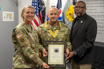 Col. Michelle M. Williams, U.S. Army Financial Management Command commander, left, and Gennaro Penn, U.S. Army Finance Corps Association president, right, present a Maj. Gen. Nathan Towson Regimental Medallion to Lt. Col. Jason L. Shick, USAFMCOM plans and operations officer, at the Maj. Gen. Emmett J. Bean Federal Center in Indianapolis June 2, 2025. The Towson was established by the U.S. Army Finance Corps Association on May 7, 1993, to recognize exceptional achievement or exemplary service by currently serving U.S. Army finance and comptroller commissioned officers, non-commissioned officers, enlisted Soldiers and civilians demonstrating exceptional leadership and whose accomplishments clearly distinguish them from their peers. (U.S. Army photo by Mark R. W. Orders-Woempner)