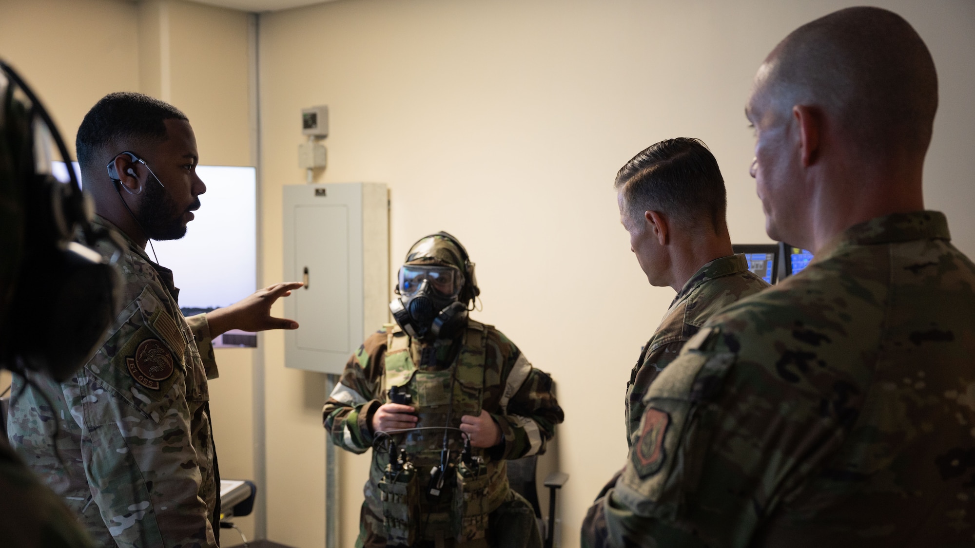 U.S. Air Force Tech. Sgt. Al Fatah, left, 51st Operations Support Squadron control tower senior watch supervisor, briefs Col. Ryan Ley, center right, 51st Fighter Wing commander, and Chief Master Sgt. Carl Vogel, right, 51st FW command chief, on a gas mask demonstration at Osan Air Base, Republic of Korea, July 15, 2025. Training is conducted throughout the year to generate combat airpower at a moment’s notice, affirming the commitment to the ROK remains ironclad and while enhancing regional stability in the Indo-Pacific. (U.S. Air Force photo by Senior Airman Rome Bowermaster)