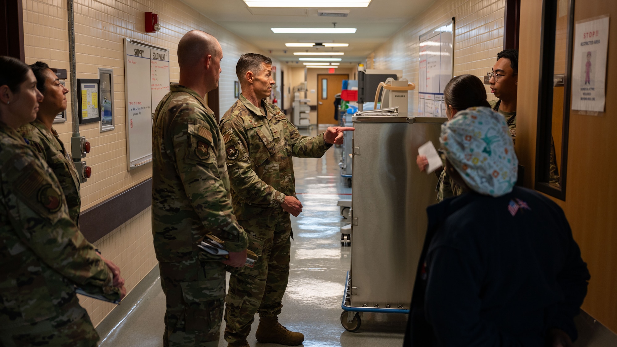 U.S. Air Force Col. Ryan Ley, center, 51st Fighter Wing commander, speaks with Senior Airman Lyle Malfoy Paras, right, 51st Healthcare Operations Squadron surgical technologist, at Osan Air Base, Republic of Korea, July 15, 2025. The 51st HCOS plays a vital role in sustaining warfighter readiness by providing comprehensive medical care and rapid response to Airmen, families, and joint partners. (U.S. Air Force photo by Senior Airman Rome Bowermaster)