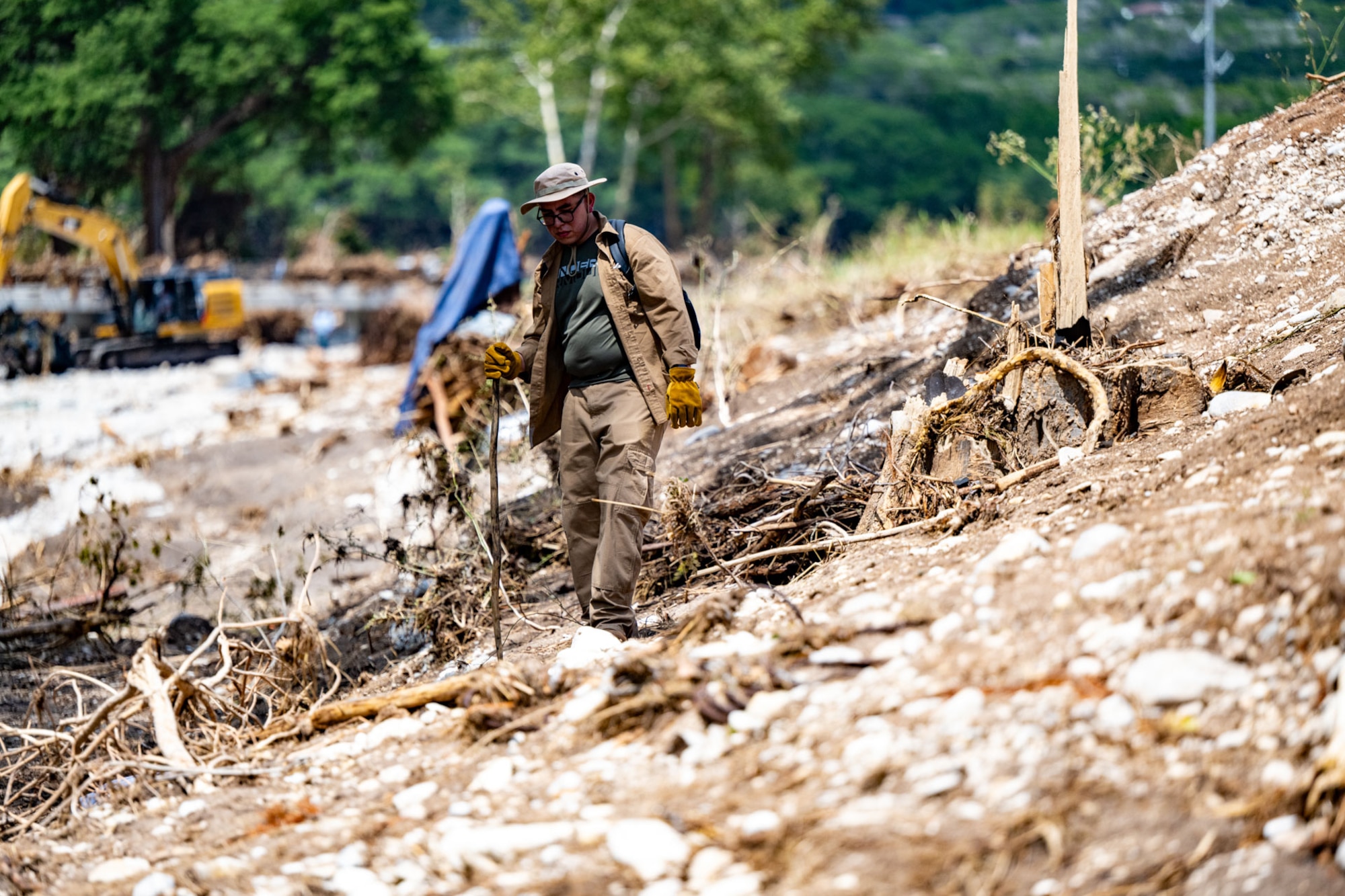 Tech. Sgt. Adrian Gomez, 426th Network Warfare Squadron cyber warfare operator, combs through the demolished landscape in Kerrville, Texas.