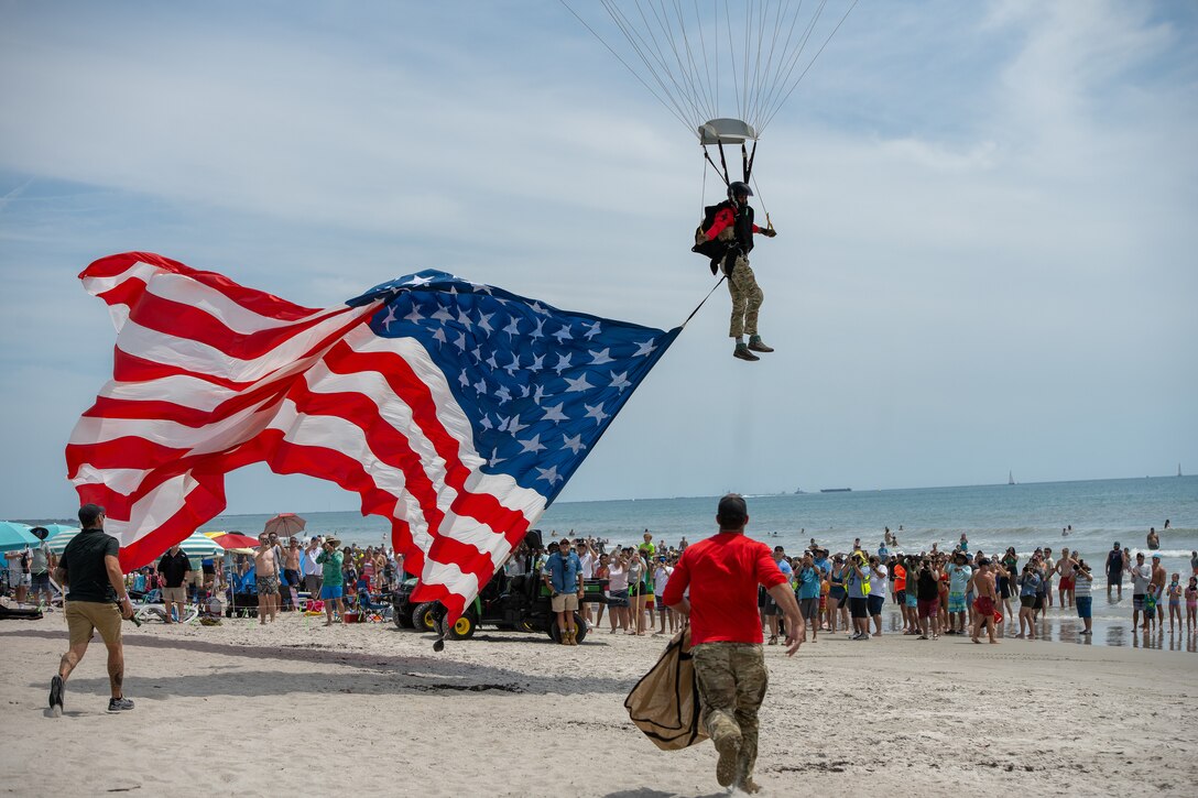 Master Sgt. Ricky Dunn, a pararescueman with the 920th Rescue Wing, lands on the beach while trailing the American flag during a demonstration at the Cocoa Beach Air Show, July 12, 2025. The display honored the legacy of Jolly 51 and Master Sgt. William Posch, one of seven Airmen killed in a 2018 HH-60G Pave Hawk crash in Iraq.
