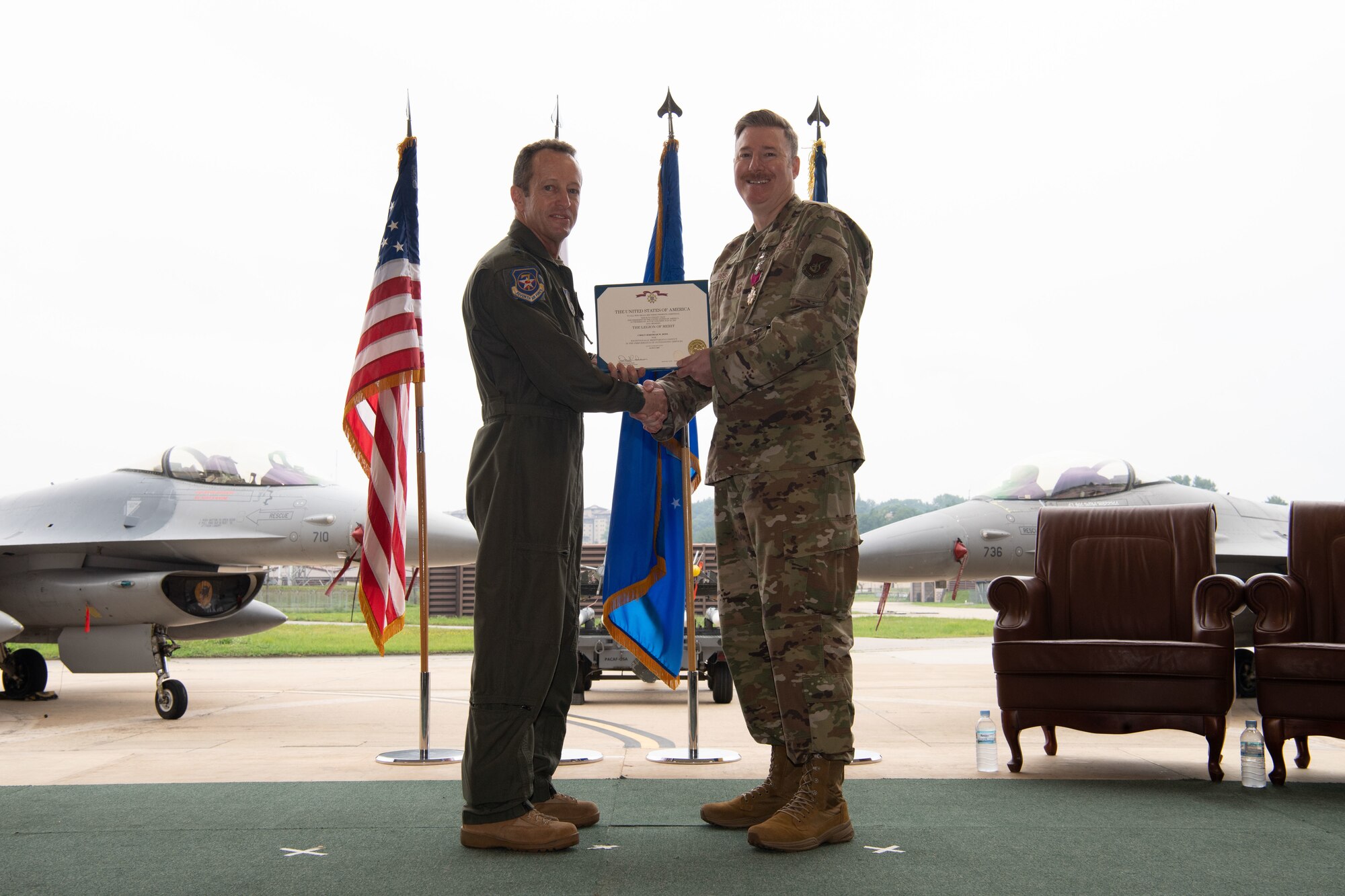 Lt. Gen. David Iverson, Seventh Air Force commander, presents the Legion of Merit to Chief Master Sgt. Jeremiah Ross, outgoing command chief master sergeant for Seventh Air Force, at Osan Air Base, Republic of Korea, July 17, 2025. The decoration recognizes Ross's exceptionally meritorious service in advising the commander on all matters regarding the welfare, readiness, and proper utilization of the command's Airmen. (U.S. Air Force photo by Staff Sgt. Dustin Braaten)