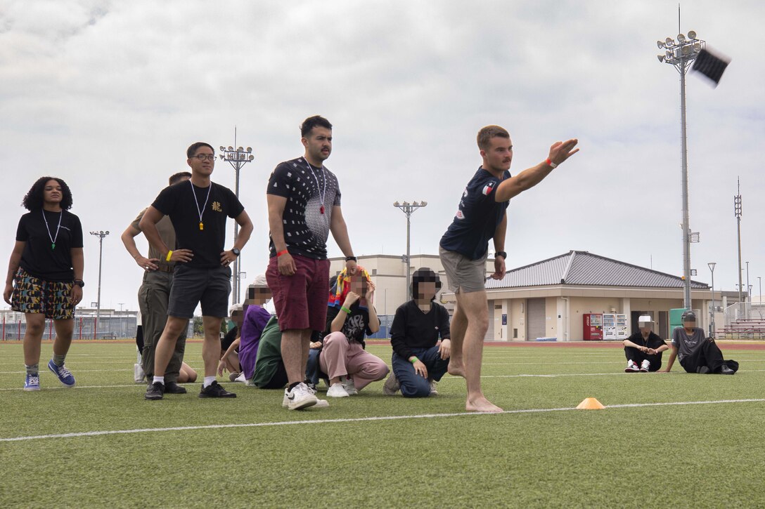 U.S. Marine Corps Lance Cpl. Kaden Wobse, an expeditionary firefighting and rescue specialist with Marine Wing Support Squadron (MWSS) 171, Marine Aircraft Group (MAG) 12, 1st Marine Aircraft Wing (MAW), plays a game of cornhole during an Aircraft Rescue and Firefighting field day event at MCAS Iwakuni, Japan, July 12, 2025. ARFF hosted a field day with a local orphanage in Iwakuni, to bring together U.S. service members and the Japanese community.  (U.S. Marine Corps photo by Lance Cpl. Isaac De Leon)