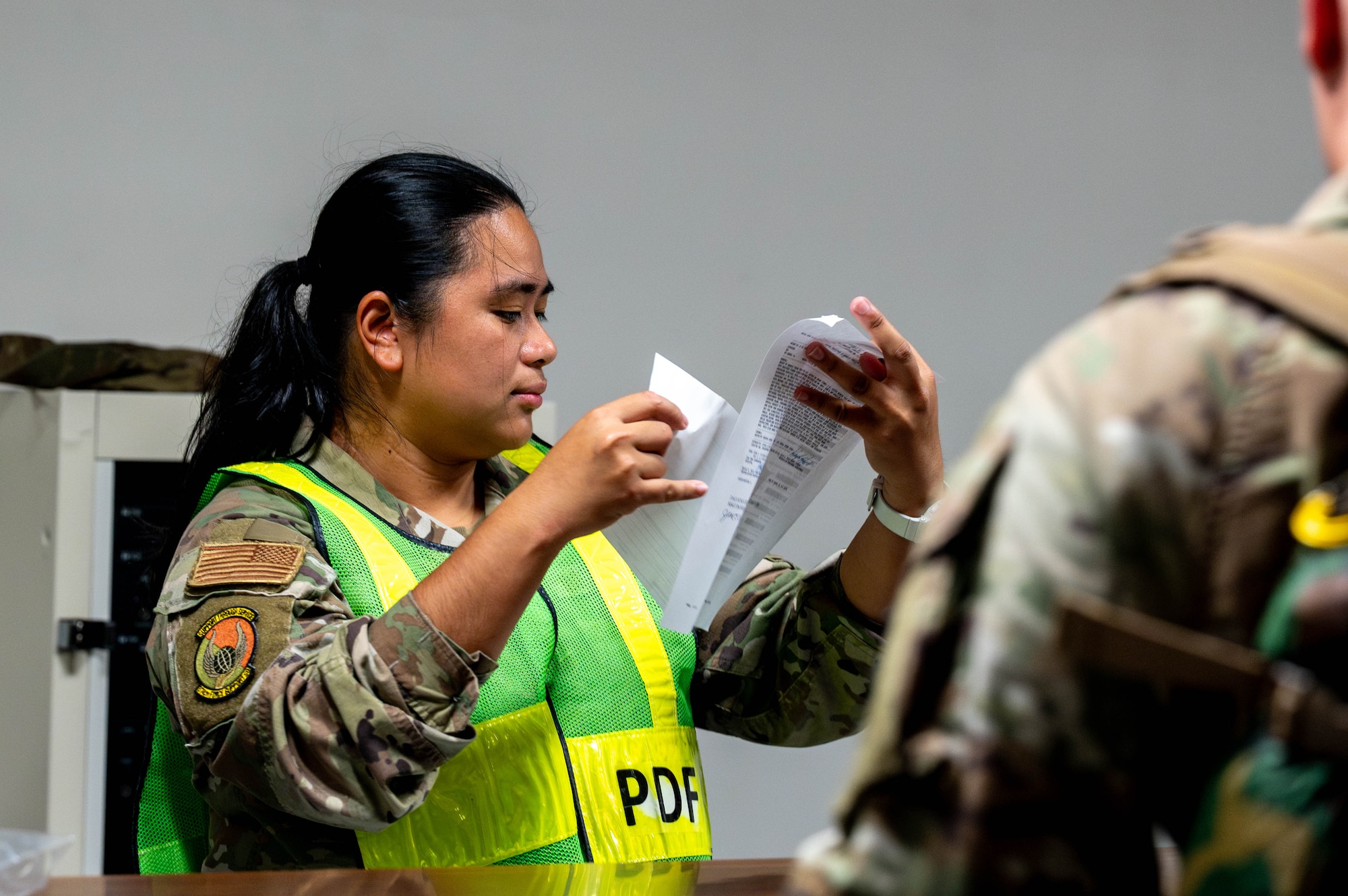 A military member reads through paperwork.
