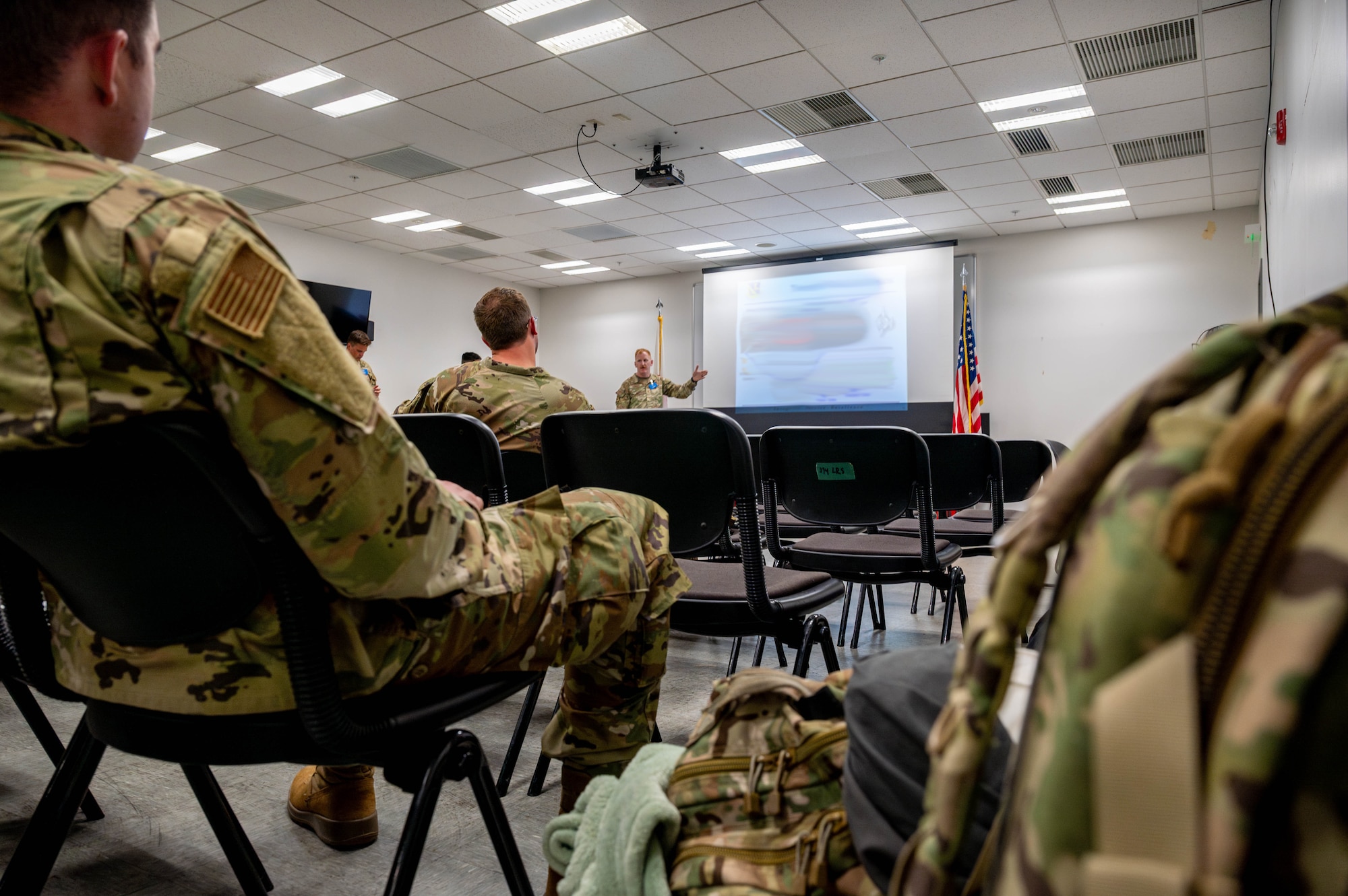 Military members listen to a briefer.