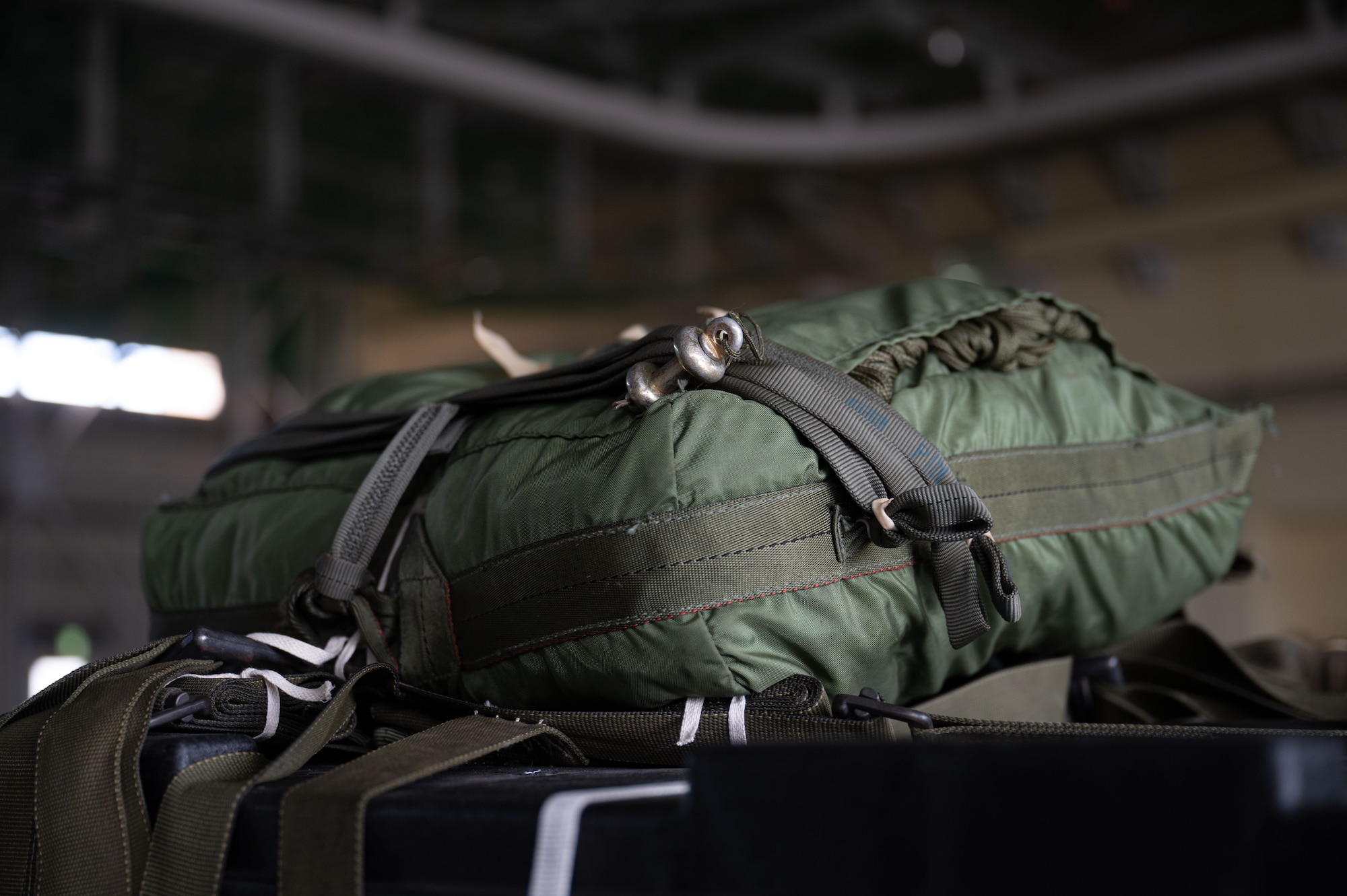 A green parachute is tied down to a cargo bundle.