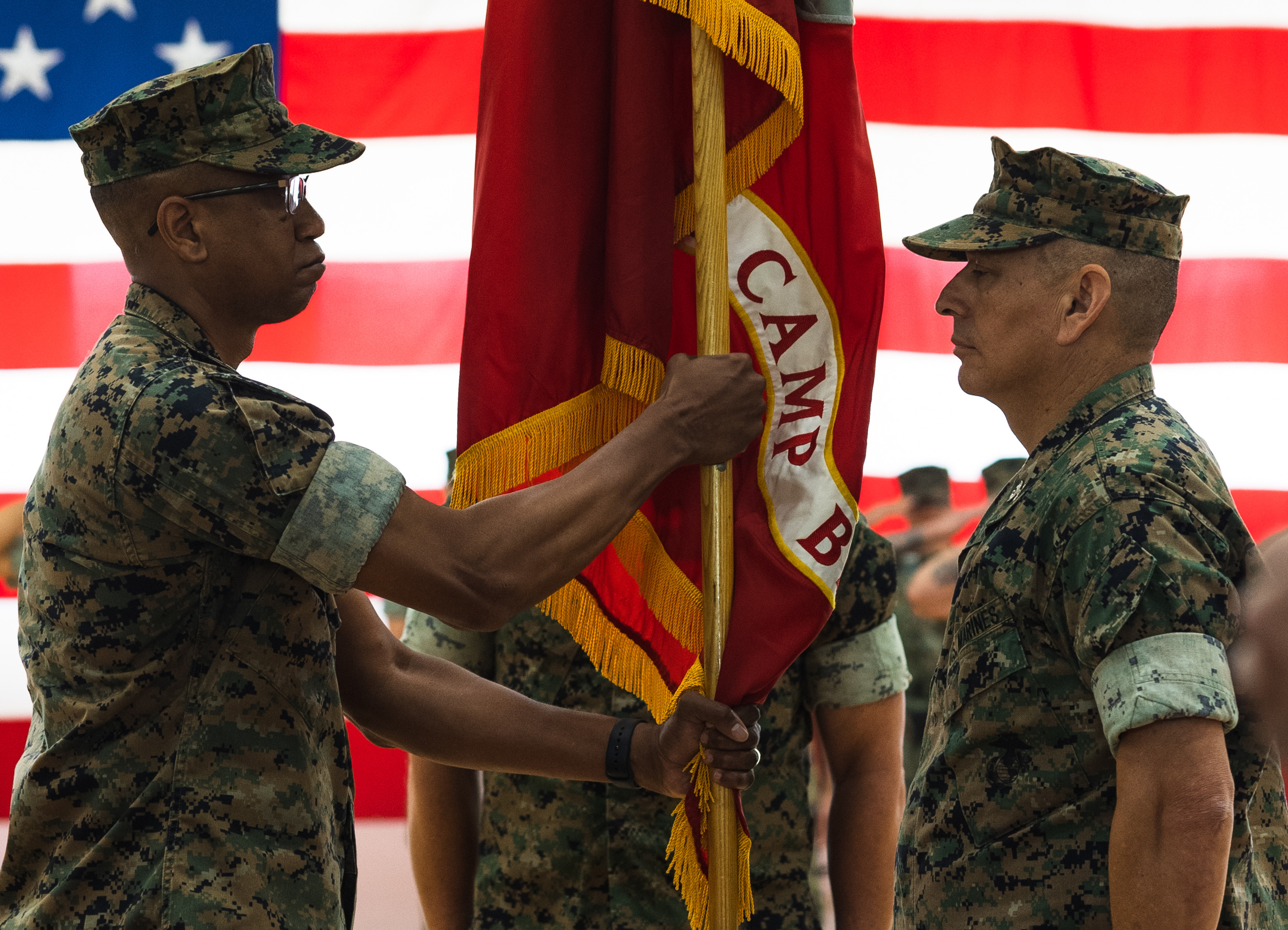U.S Marine Corps Col. Ricahrd Marshall Jr., oncoming commanding officer, Marine Corps Base Camp Blaz, takes the command colors from Col. Ernest Govea, outgoing commanding officer, MCB Camp Blaz, during a change of command ceremony on Marine Corps Base Camp Blaz, Guam, July 17, 2025.  Col. Govea relinquished command of Camp Blaz to Col. Marshall after serving as the commanding officer since July of 2023. The change of command ceremony is an honored tradition, which signifies the transfer of command responsibility from one commander to another. (U.S. Marine Corps photo by Cpl. Brayden Daniel)