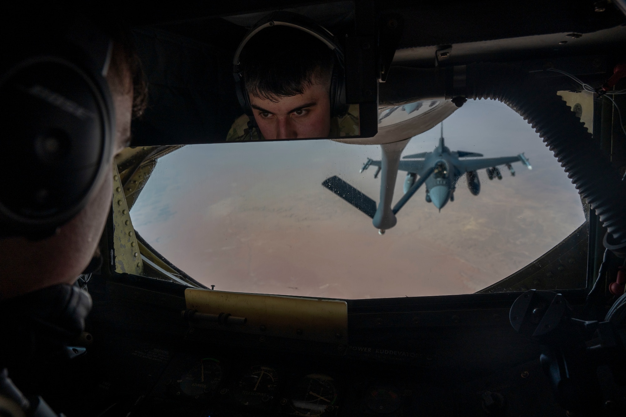 A boom operator prepares to refuel an F-16.