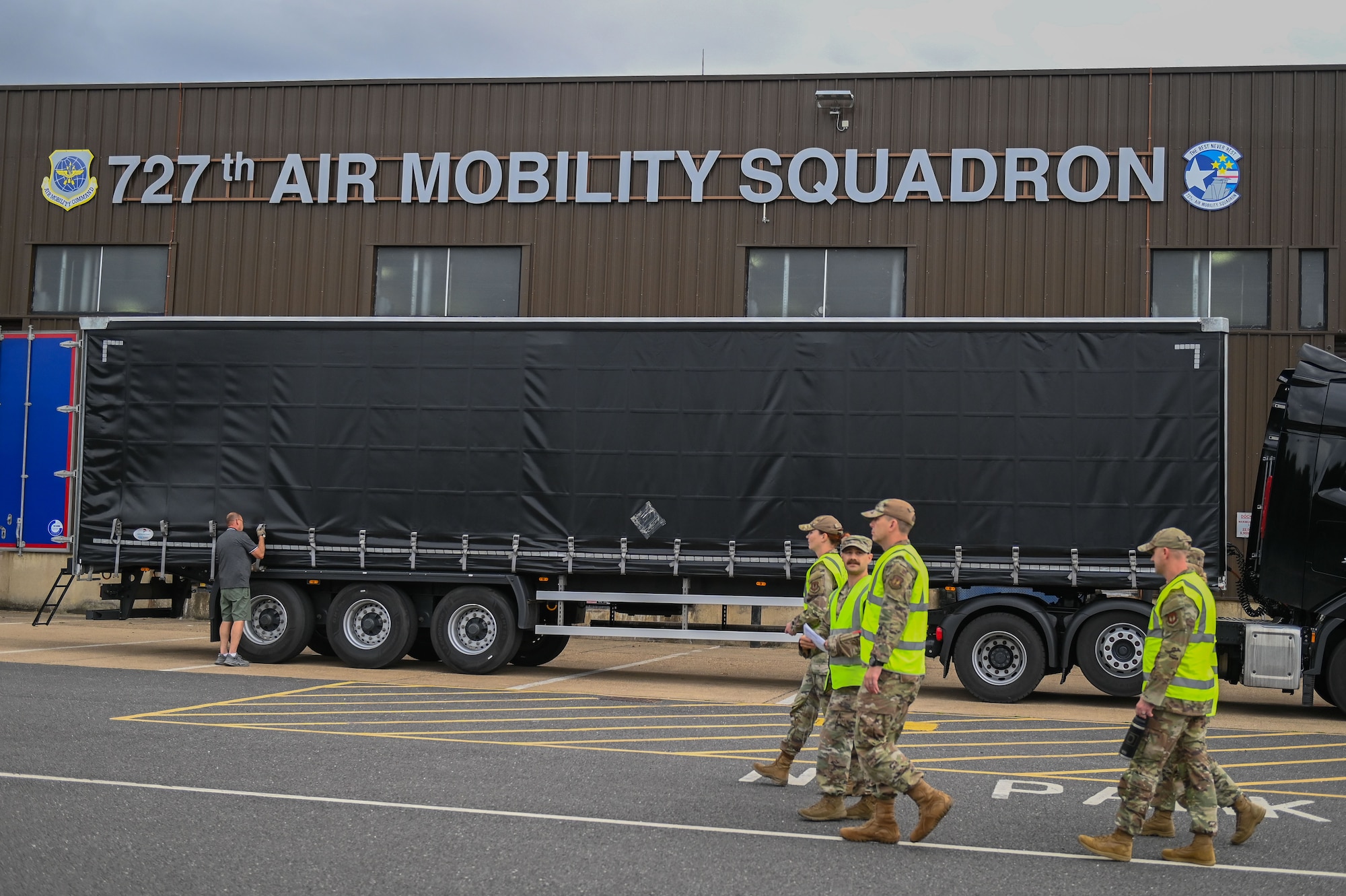 U.S. Air Force Airmen walk through the 727th Air Mobility Squadron’s cargo area during the 100th Air Refueling Wing command team “Day in the Life” integration of a cargo deployment functions walkthrough at RAF Mildenhall, England, July 15, 2025.