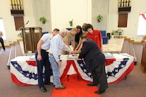 A group of personnel representing the longest and shortest serving members from Strategic Weapons Facility, Atlantic’s (SWFLANT) government, military and industry teams, ceremoniously cut a cake with Vice Adm. Johnny Wolfe Jr., Director, Strategic Systems Programs during a celebratory event held at the Naval Submarine Base Kings Bay, Ga. chapel on July 3, in honor of the 70th anniversary of Strategic Systems Programs (SSP).