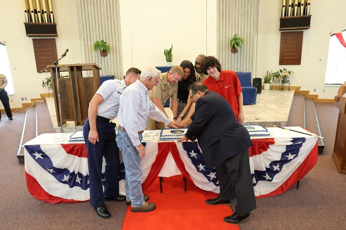 A group of personnel representing the longest and shortest serving members from Strategic Weapons Facility, Atlantic’s (SWFLANT) government, military and industry teams, ceremoniously cut a cake with Vice Adm. Johnny Wolfe Jr., Director, Strategic Systems Programs during a celebratory event held at the Naval Submarine Base Kings Bay, Ga. chapel on July 3, in honor of the 70th anniversary of Strategic Systems Programs (SSP).