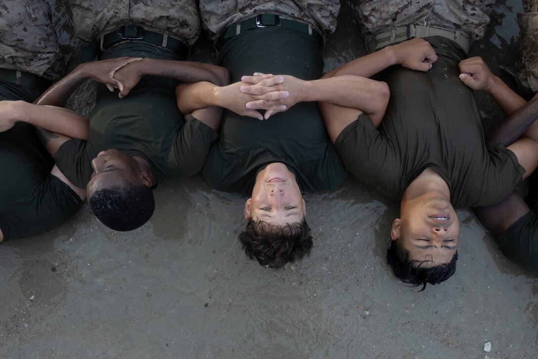 U.S. Marines with 2nd Marine Logistics Group Corporals Leadership School perform group sit-ups during a beach workout while participating in Corporals Leadership School on Marine Corps Base Camp Lejeune, North Carolina, July 16, 2025. Corporals Leadership School is a four-week course designed to enhance skills to be effective small unit leaders and expand their knowledge as noncommissioned officers in the U.S. Marine Corps. (U.S. Marine Corps photo by Lance Cpl. Franco Lewis)