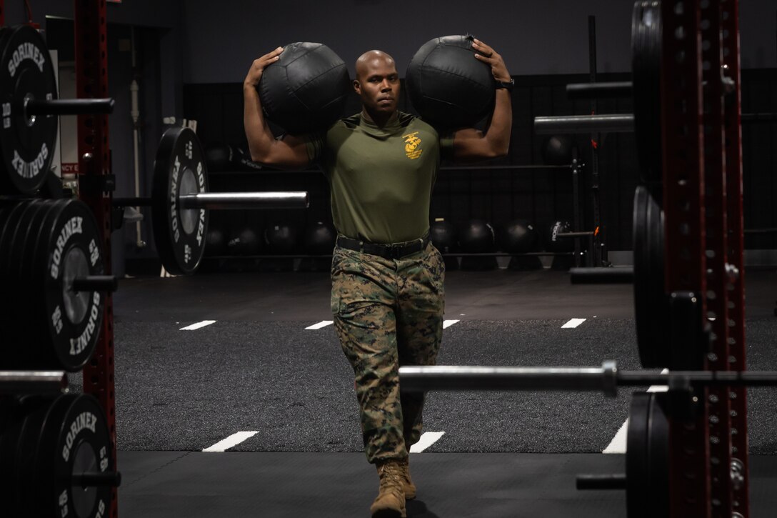U.S. Marine Corps Gunnery Sgt. Tyon Downing, an engineer equipment operator with 2nd Distribution Support Battalion, 2nd Marine Logistics Group, carries equipment prior to a workout he setup in the Human Performance Center at Marine Corps Base Camp Lejeune, North Carolina, July 14, 2025. The Human Performance Center provides programs that aim to inform, educate, and equip unit leaders with resources to support the physical, mental, spiritual, and social fitness of Marines and Sailors in order to optimize readiness, performance, and resilience. (U.S. Marine Corps photo by Lance Cpl. Brady V. Hathaway)